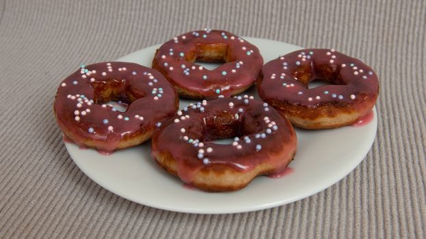 assorted donuts with chocolate frosted, pink glazed and sprinkles donuts.