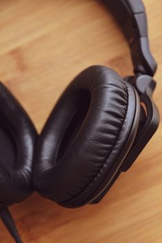 Black headphones on wooden background.