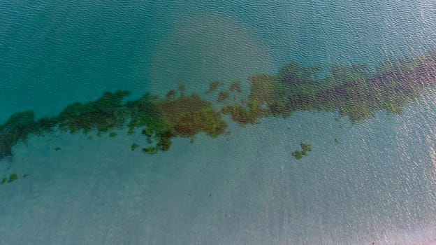 Aerial view of sea waves crashing on beach without people. light ripple on water