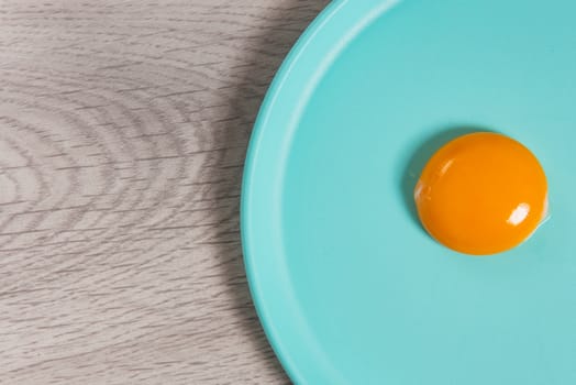 egg yolk on plate and wooden table