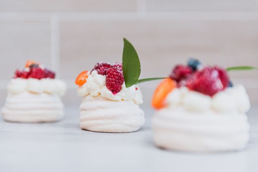 Pavlova meringue desert cake with cream and small fruits