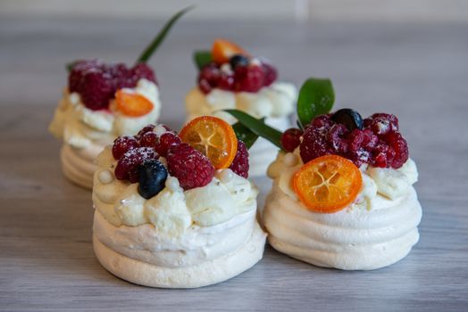 Pavlova meringue desert cake with cream and small fruits