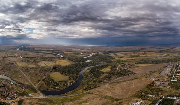 Aerial view on flowing river and town. Akhtuba River and Volga River