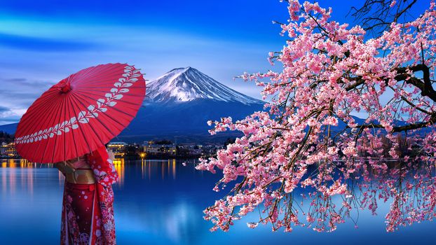 Asian woman wearing japanese traditional kimono at Fuji mountain and cherry blossom, Kawaguchiko lake in Japan.