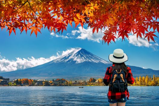 Woman traveler with backpack looking to Fuji mountains in Autumn, Japan.