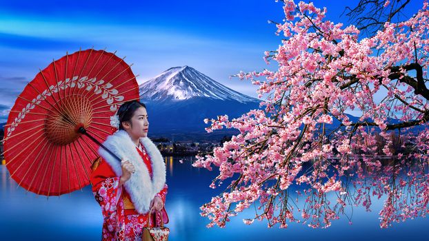 Asian woman wearing japanese traditional kimono at Fuji mountain and cherry blossom, Kawaguchiko lake in Japan.