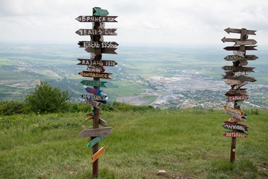 Columns with direction and distance to cities. Wooden columns on the hill