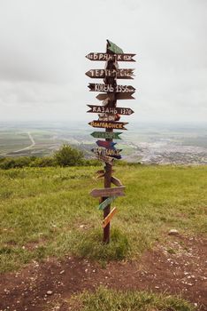 Columns with direction and distance to cities. Wooden columns on the hill