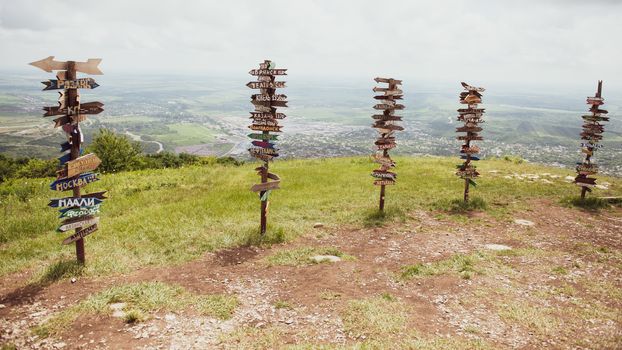 Columns with direction and distance to cities. Wooden columns on the hill