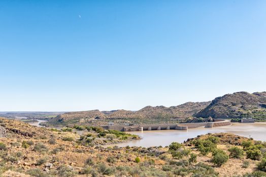 The Vanderkloof Dam in the Orange River (Gariep River) as seen from Vanderkloof town. The river below the dam wall and the moon are visible