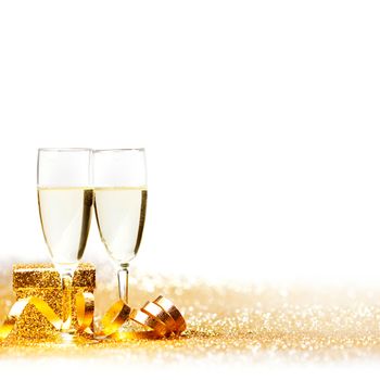 Glasses of champagne and decorative golden ribbon isolated on white