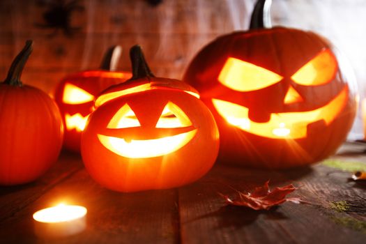 Jack O Lantern Halloween pumpkin, spiders on web and burning candles