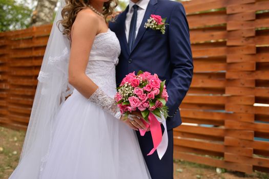 nice wedding bouquet in bride's hand. Kiss across bouquet