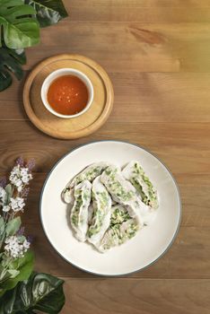 Top view Vietnamese Steamed Rice Dumplings served with spicy chili sauce over wooden table