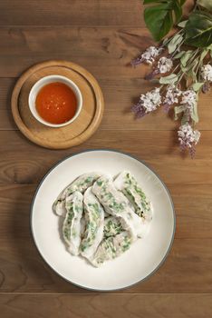 Top view Vietnamese Steamed Rice Dumplings served with spicy chili sauce over wooden table