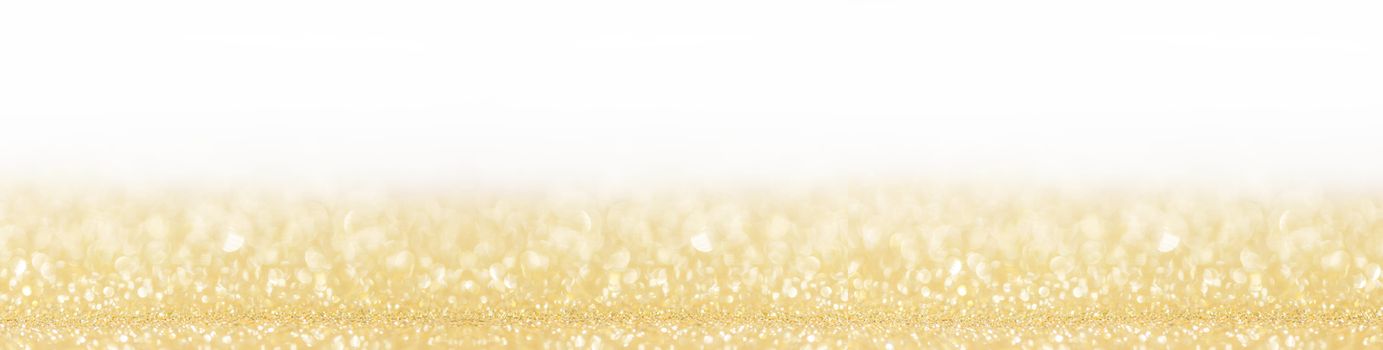 Golden festive glitter background with defocused lights , white copy space