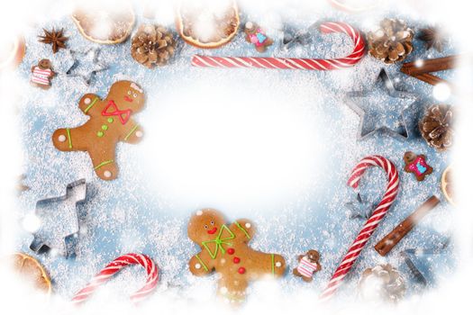 Christmas food frame. Gingerbread cookies, spices and decorations on blue background with copy space