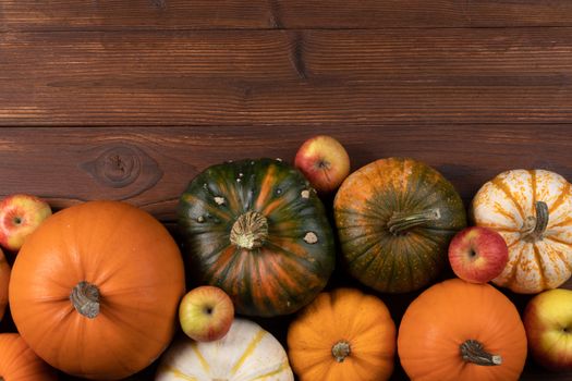 Autumn harvest still life with pumpkins and apples on wooden background , top view