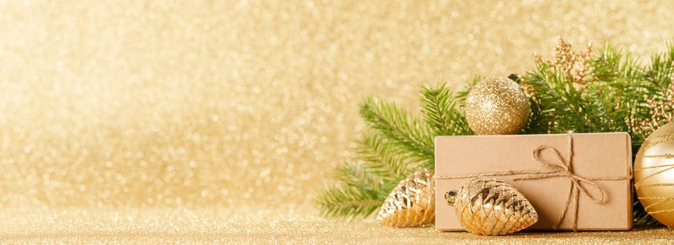 Christmas toys, decorations, present gift box wrapped in kraft paper on golden glitter background, copy space