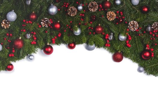Christmas Border frame of tree branches on white background with copy space isolated, red and silver decor, berries, stars