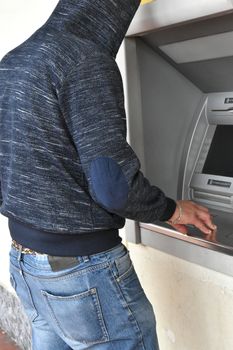 Man while rubbing a cash machine atm