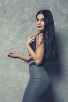 attractive cute brunette girl posing in gray clothes