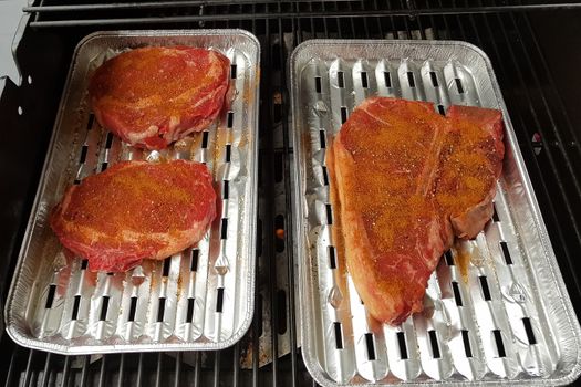 Grilling steaks on a blazing grill. Shot with selective focus