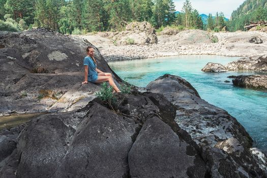 Woman resting at river in Altai Mountains territory