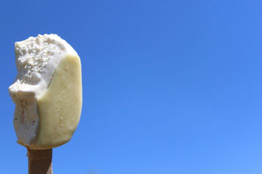 The picture shows an ice cream on a stick and the blue sky.