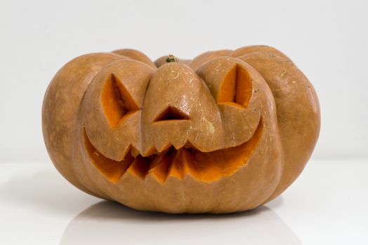 orange halloween pumpkin with carving, crushed and collapsible typology, on a background in nature or white