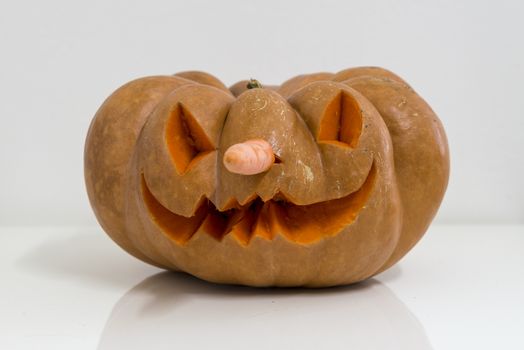 orange halloween pumpkin with carving, crushed and collapsible typology, on a background in nature or white