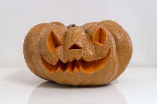 orange halloween pumpkin with carving, crushed and collapsible typology, on a background in nature or white