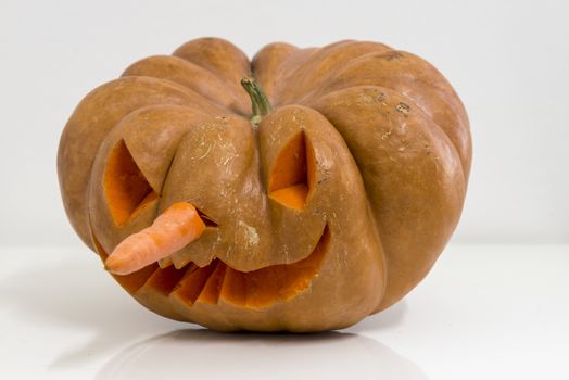 orange halloween pumpkin with carving, crushed and collapsible typology, on a background in nature or white