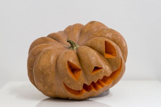 orange halloween pumpkin with carving, crushed and collapsible typology, on a background in nature or white