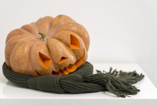 orange halloween pumpkin with carving, crushed and collapsible typology, on a background in nature or white