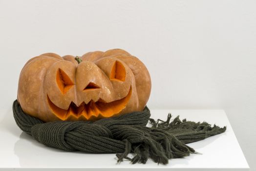 orange halloween pumpkin with carving, crushed and collapsible typology, on a background in nature or white