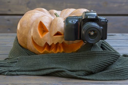 orange halloween pumpkin with carving, crushed and collapsible typology, on a background in nature or white