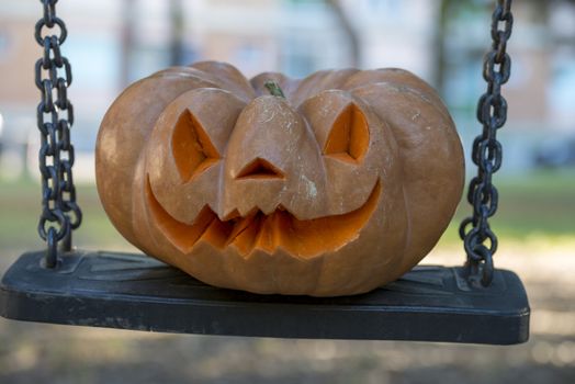 orange halloween pumpkin with carving, crushed and collapsible typology, on a background in nature or white