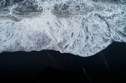 Aerial view of Black sand beach and ocean waves in Iceland.