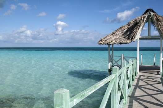 Wooden pier in the Caribbean with turquoise crystal clear water as a background.
