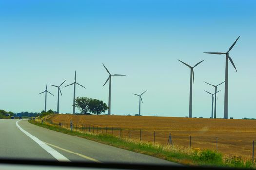 Sustainable green energy. Electric windmill generators in the sunrise