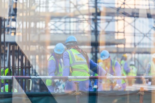 Unrecognizable labor workers working on a construction site.