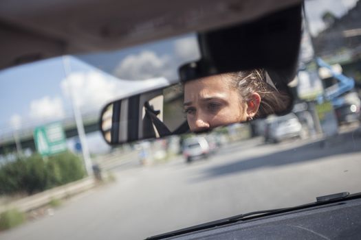 Car's rearview mirror with girl mirrored