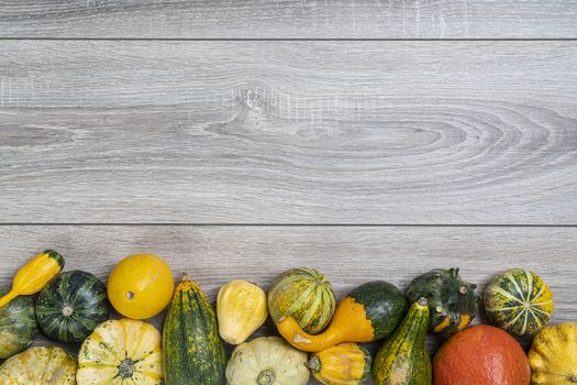 Some small pumpkins on a wooden table in the autumn