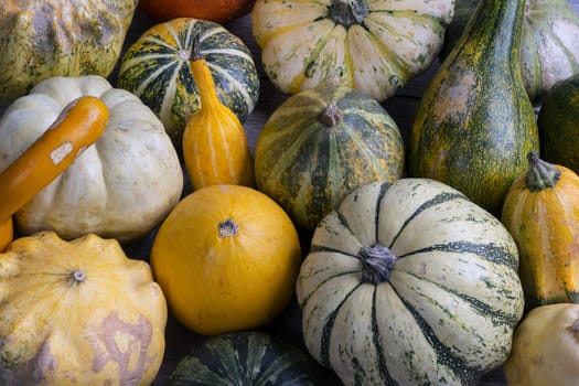 Some small pumpkins on a wooden table in the autumn