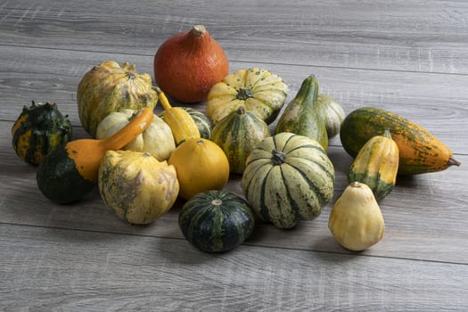 Some small pumpkins on a wooden table in the autumn