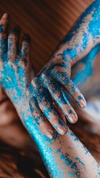 Blue glitter on woman hands. Smooth movements of the hands. Femininity and beauty