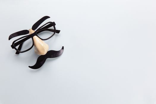 Carnival mask with moustache, nose and glasses on grey background, copy space. Concept Movember, men's health, prostate cancer awareness month, charity, Father's Day. Horizontal. Minimalism flat lay.