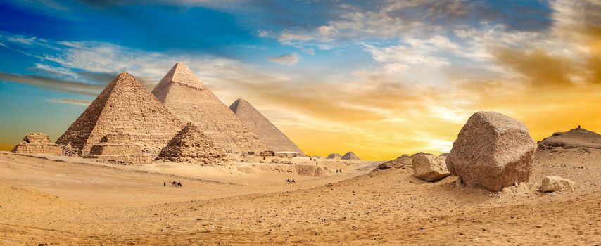 Egyptian pyramids in the desert at sunset