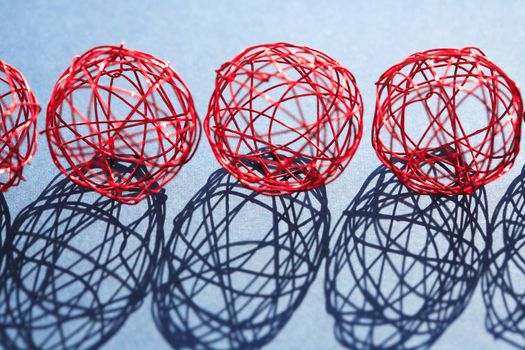 Set of red balls made from wire in a row against sun light